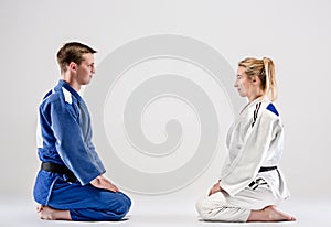 The two judokas fighters posing on gray