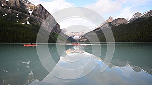 Two kayaks crossing the mirror-like surface of Lake Louise. Banff National Park AB Canada