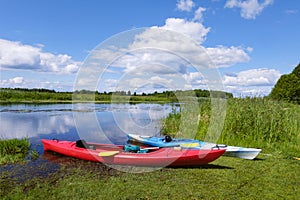 Two kayaks by the river bank. Scenic rural landscape of wild river, rafting along a river, water sport concept