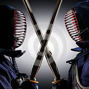 Two kendo fighters with shinai opposite each other.