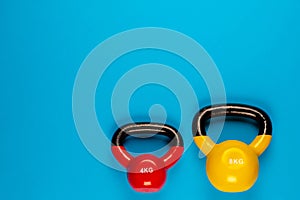 Two kettle bells of different sizes on blue background