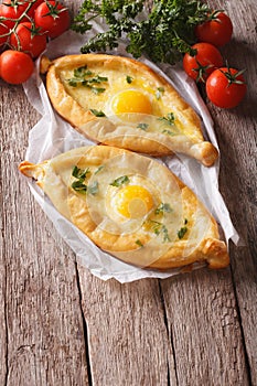 Two khachapuri and fresh vegetables close-up on the table. verti