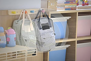 Two kid backpacks near by a shelf