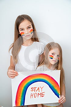 Girls drew rainbow and poster stay home. photo