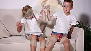 Two kids boy with girl reconciled on sofa, slow motion