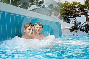 Two kids boys having fun in outdoor pool. Summer holiday. Summertime kids weekend. Children having fun, brothers on