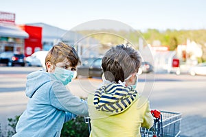 Two kids boys in medical mask as protection against pandemic coronavirus disease. Children using protective equipment photo
