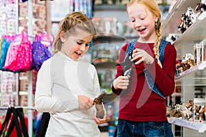 Two kids buying toys in toy store