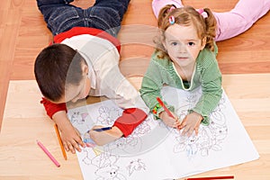 Two kids coloring on the floor