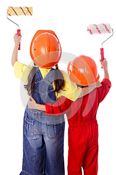 Two kids in coveralls with paint rollers