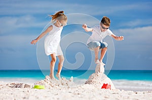 Two kids crushing sandcastle