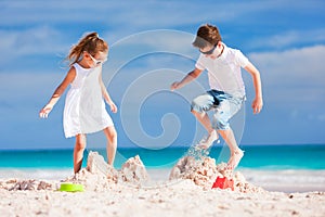 Two kids crushing sandcastle photo