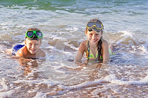 Two kids in diving masks on the sea