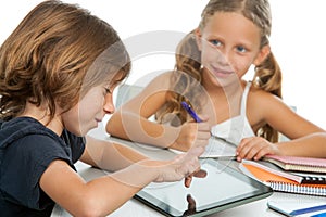 Two kids doing homework on digital tablet.