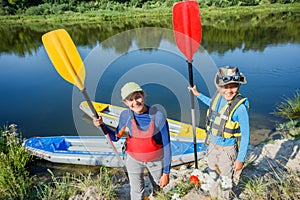 Two kids enjoying kayak ride on beautiful river. Little boy and teenager girl kayaking on hot summer day. Water sport