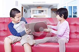 Two kids fighting over a notebook