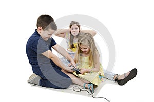 Two kids fighting for video games. Annoyed old sister covering her ears with her hands can not listening