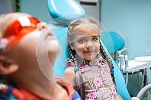 Two kids having fun and wearing medical eyeglasses during visit to dentist office