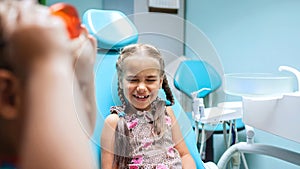 Two kids having fun and wearing medical eyeglasses during visit to dentist office