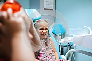 Two kids having fun and wearing medical eyeglasses during visit to dentist office