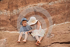 Two kids hugging sitting in the mountain. Big sister and brother