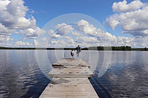 Two kids jumping into Lake Ranuanjarvi, Finland in the summer