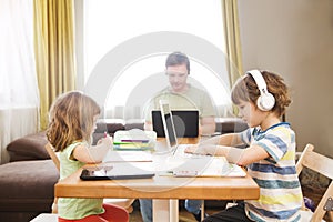 Two kids learn at home online.