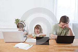 Two kids learn at home online.