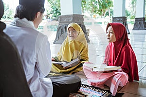 two kids learning to read quran with muslim teacher or ustad