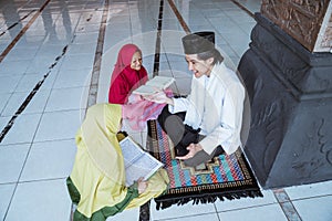 two kids learning to read quran with muslim teacher or ustad