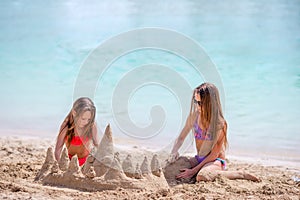 Two kids making sand castle and having fun at tropical beach