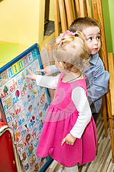 Two kids in Montessori preschool Class. Little girl and boy playing