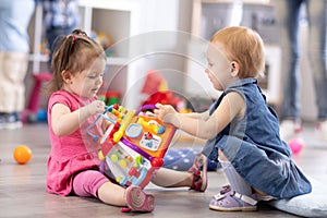 Two kids playing with blocks in children room