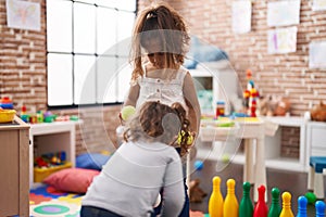 Two kids playing bowling at kindergarten