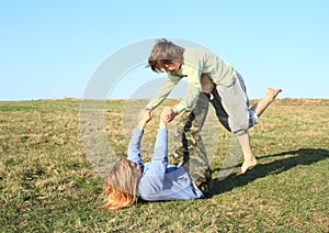 Two kids playing and exercising yoga on meadow