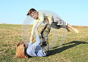 Two kids playing and exercising yoga on meadow