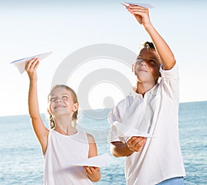 Two kids playing paper planes
