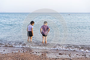 Two kids playing on sea beach in summer day.