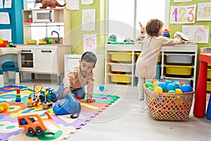 Two kids playing with telephone toy sitting on floor at kindergarten