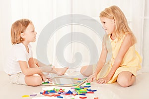 Two kids playing with wooden mosaic in their room