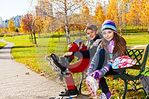 Two kids putting on roller blades