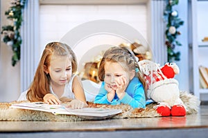 Two kids read a book. Two sisters. Concept New Year, Merry Chris