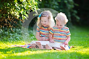 Two kids reading in summer garden