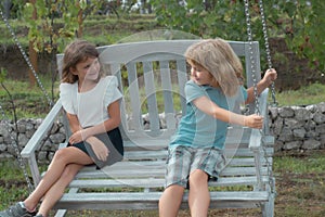 Two kids relaxing outdoors at summer park. Brother and sister happy walking in nature. Siblings boy and girl playing in