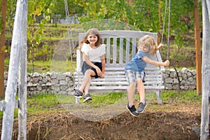 Two kids relaxing outdoors at summer park. Brother and sister happy walking in nature. Siblings boy and girl playing in