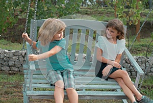 Two kids relaxing outdoors at summer park. Brother and sister happy walking in nature. Siblings boy and girl playing in