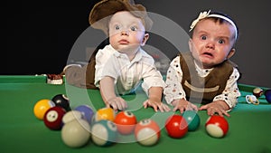 Two kids in retro clothes on a billiard pool table. Happy family kid dream concept. Lifestyle twin brother and sister