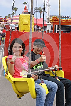 Two Kids Riding a Ride at the Fair or Carnival