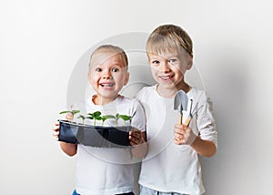 Two kids with sprouts and gardening tools, ecology and environment theme on white background