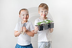 Two kids with sprouts and gardening tools, ecology theme on white background
